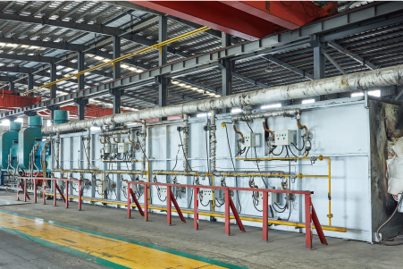 Industrial heat treatment zone with multiple annealing units and drive systems, representing AKS's modular equipment layout.