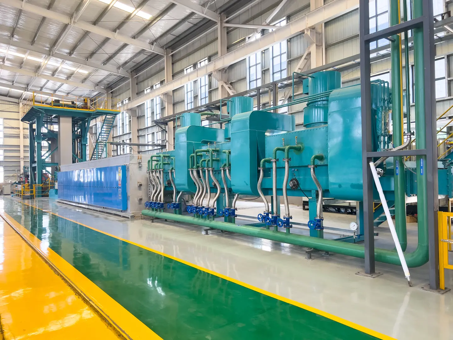 Modern industrial furnace with intricate piping in a well-lit factory setting