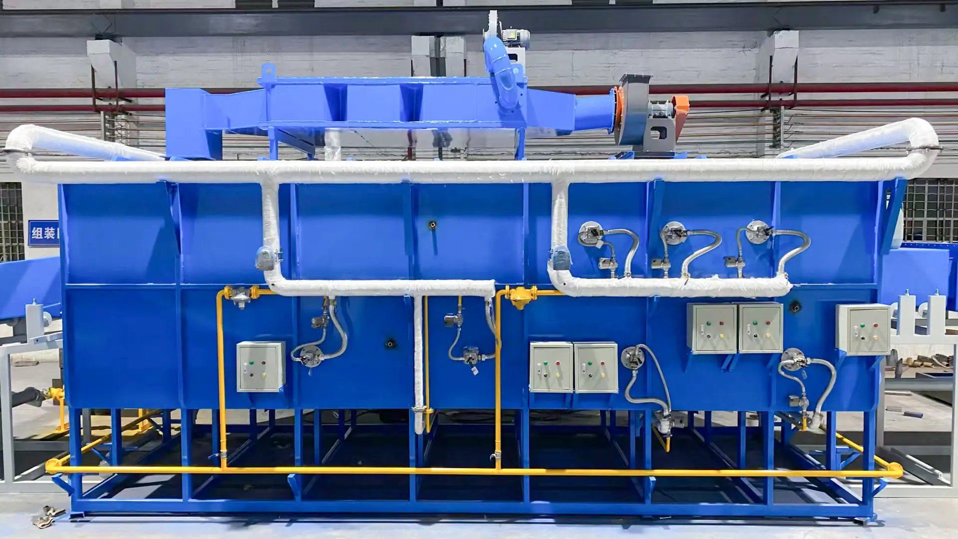 High-tech blue annealing furnace with precision controls and insulated piping in industrial setting