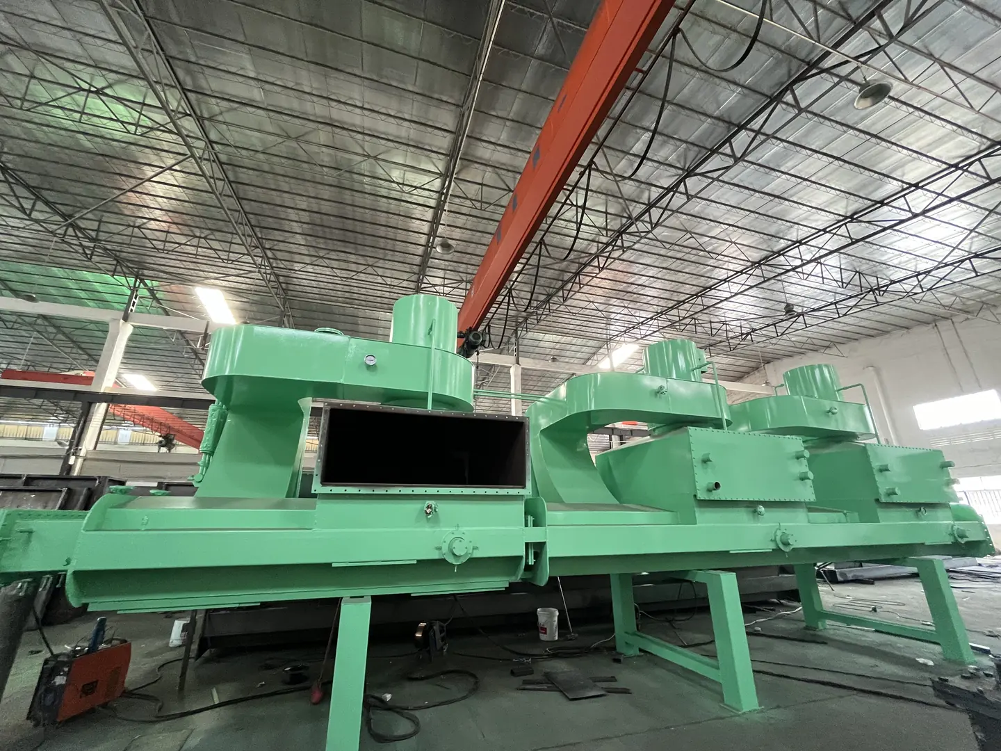 Green industrial annealing furnace in large factory setting